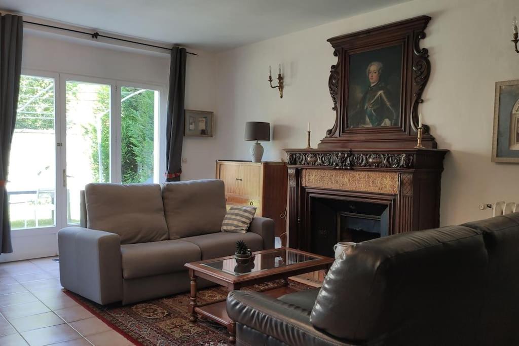 un salon avec un canapé et une cheminée dans l'établissement Charmant 110m2 avec jardin privé, à Maisons-Laffitte