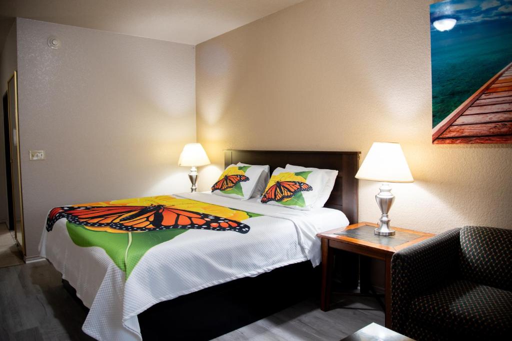 a bedroom with a bed with a butterfly blanket on it at Premium Inn and Suites in Killeen