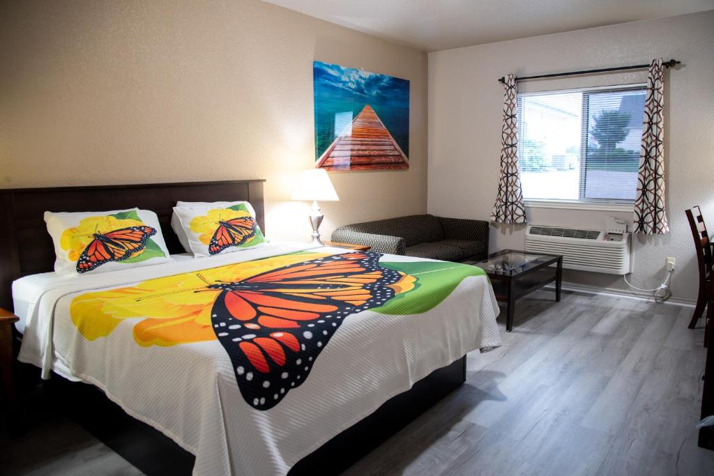 a bedroom with a bed with a monarch butterfly on it at Premium Inn and Suites in Killeen