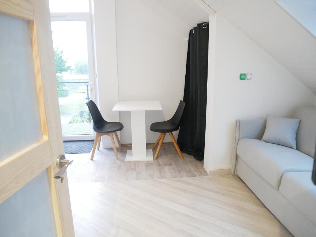 a living room with a couch and a table at Villa Cathy Studio Terrasse Léane in Aix-les-Bains