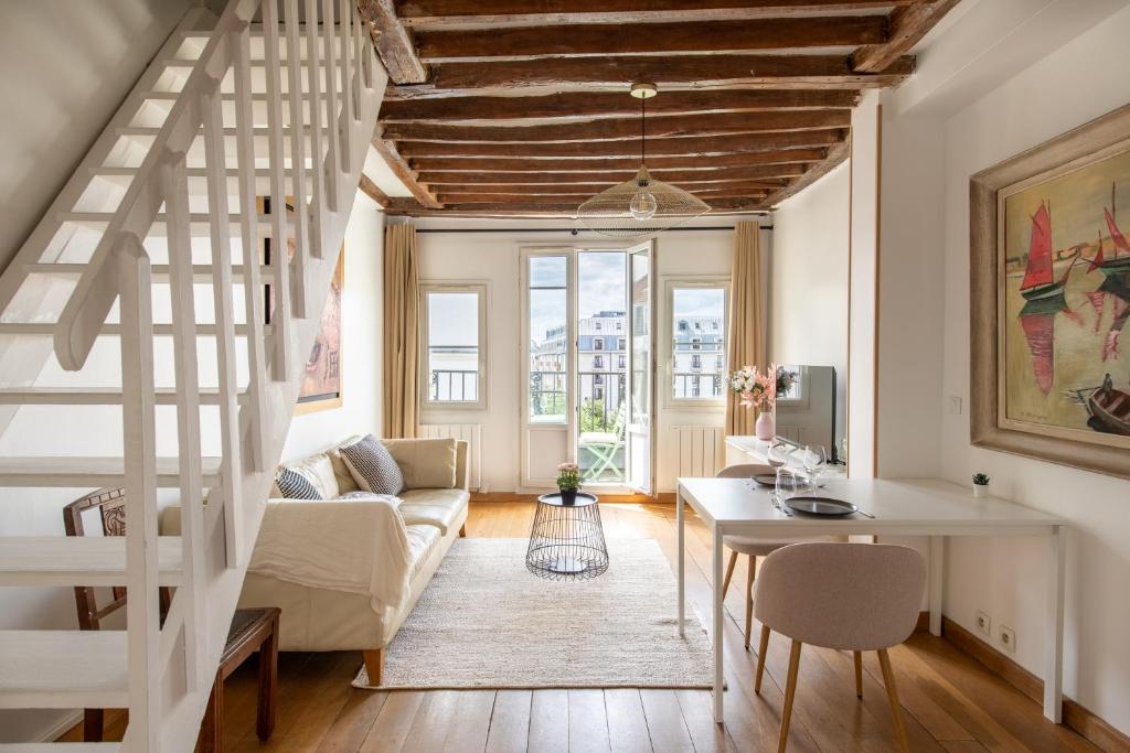 un salon avec un escalier et une table dans l'établissement Géranimus 36A : Heart of Paris, à Paris