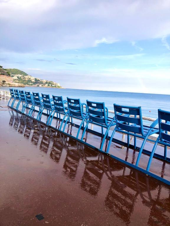 - une rangée de chaises bleues assises sur la plage dans l'établissement Studio palais des arts, à Nice