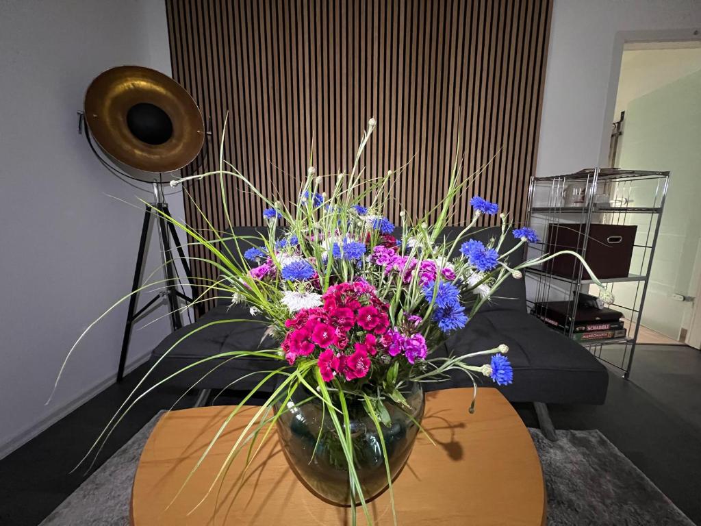 a vase filled with purple and blue flowers on a table at Ferienwohnung vor den Toren Berlins in Heidesee