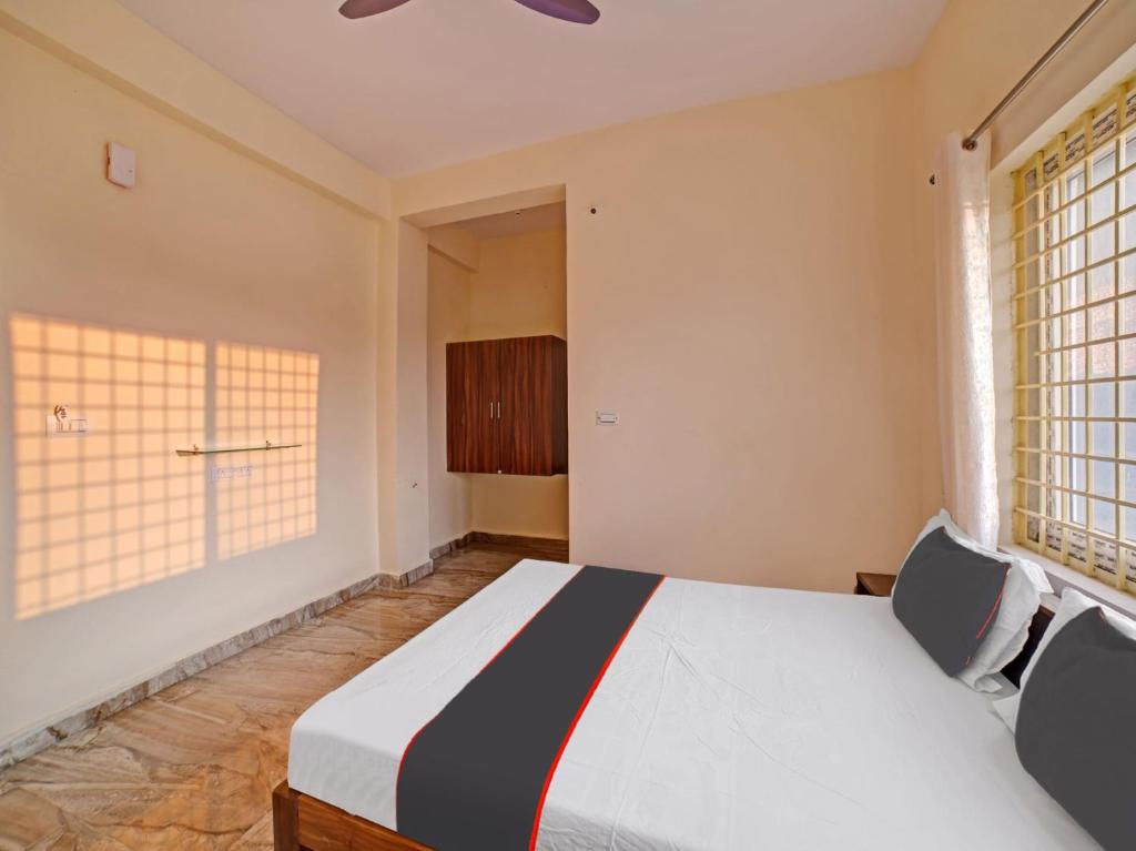 - une chambre avec un lit et 2 fenêtres dans l'établissement OYO Hotel Rajaganga Lodge, à Hassan