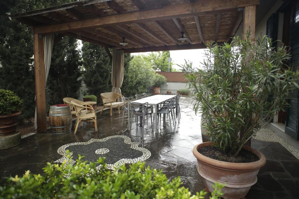 eine Terrasse mit einem Tisch und Stühlen im Regen in der Unterkunft Villa la Catena in Ulignano