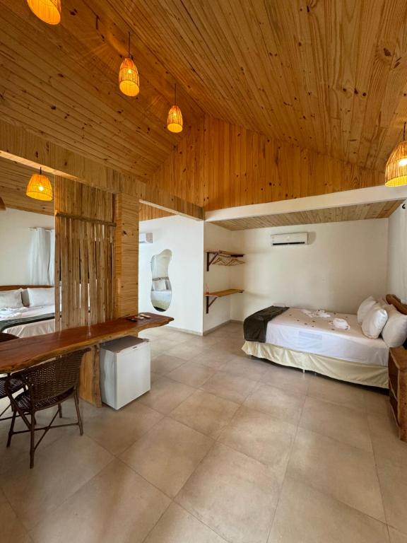 1 dormitorio con cama y techo de madera en Pousada Corais do Bitingui en Japaratinga