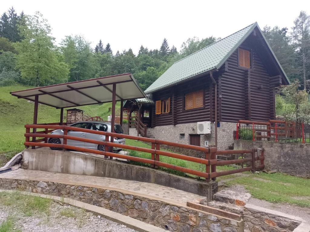 une cabane en rondins avec un pont et une maison dans l'établissement Chalet Ograjčica, à Kuželj