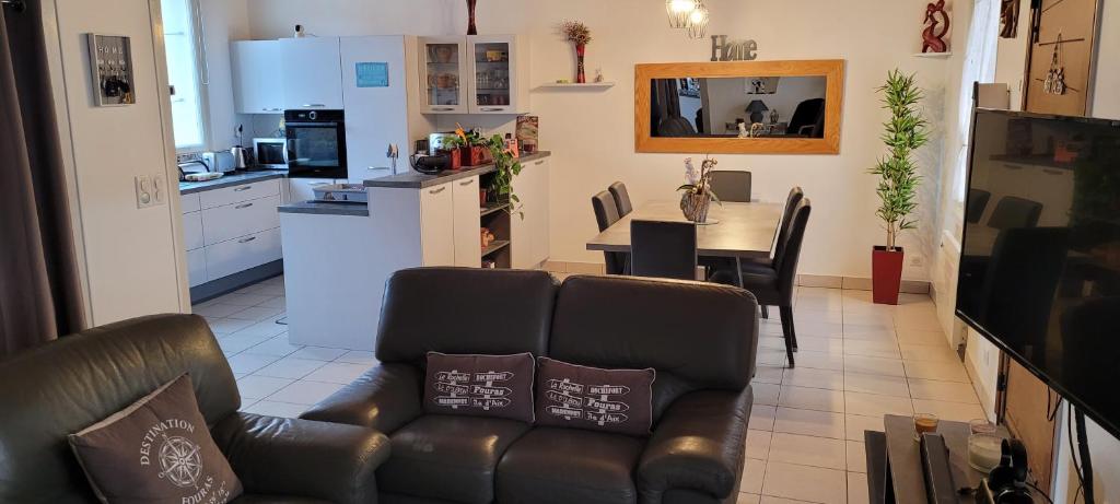 un salon avec un canapé et une cuisine dans l'établissement Maison Fouras centre 3 étoiles, à Fouras