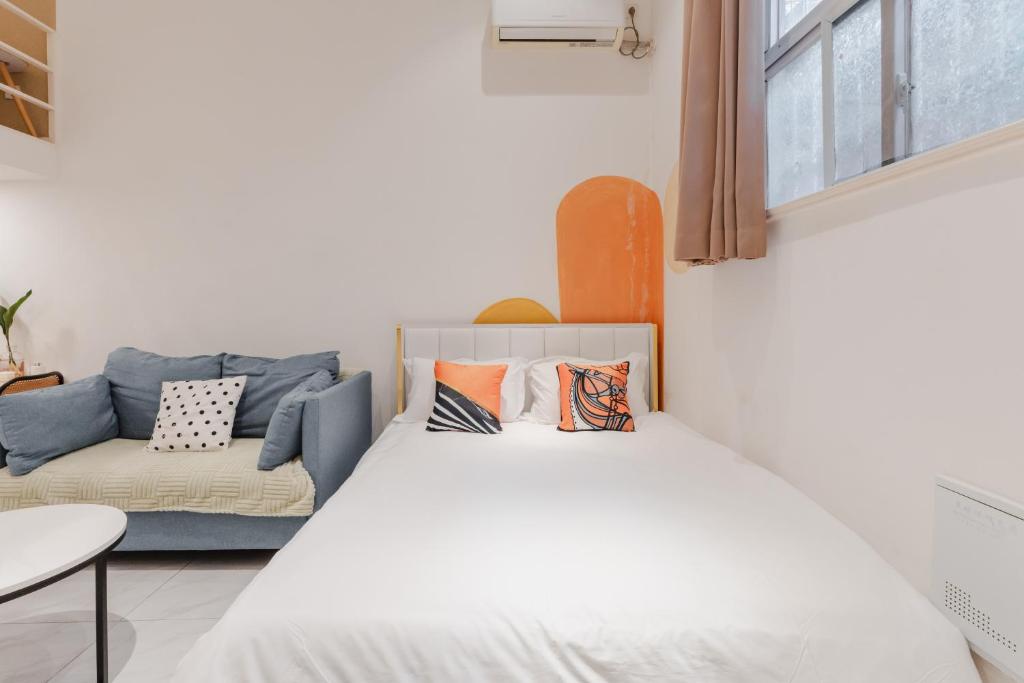 a bedroom with a bed and a couch at Shanghai Hills& XING 479 B&B in Shanghai
