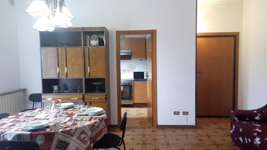 a dining room with a table and a kitchen at Casa Luciano Bellaria Centro in Bellaria-Igea Marina