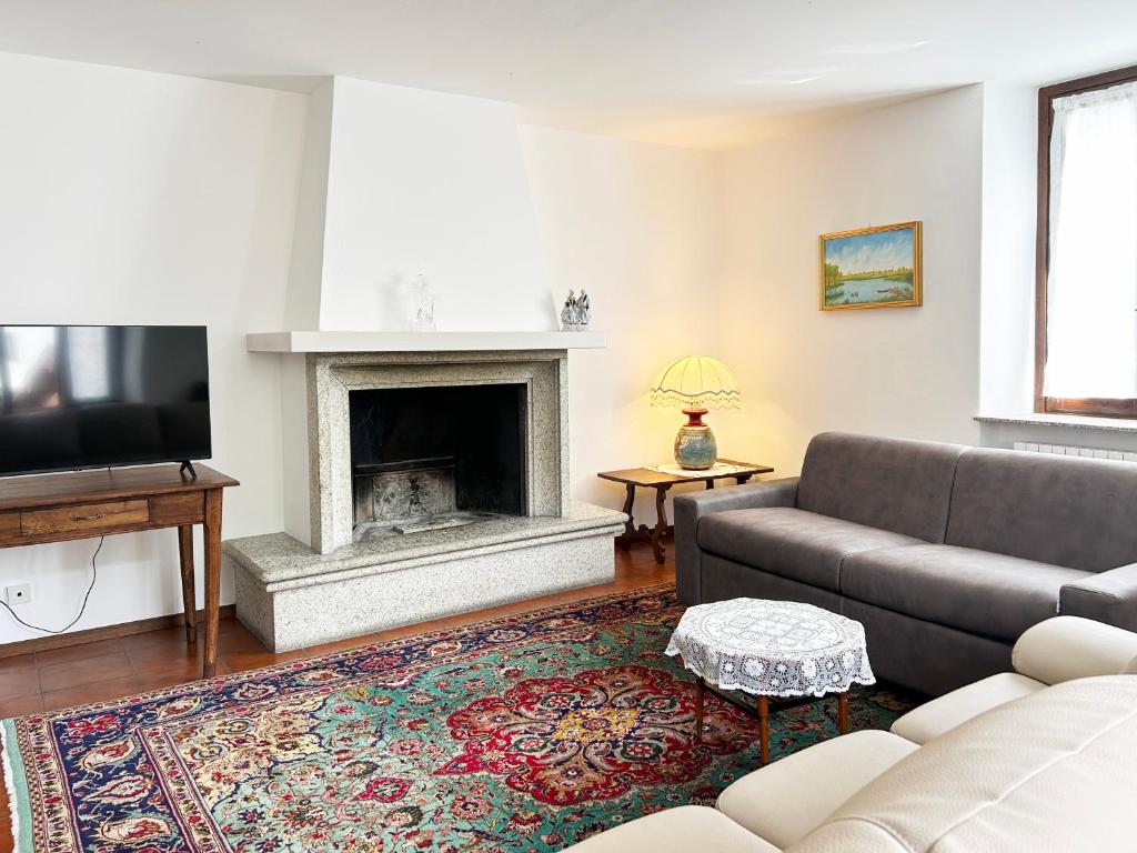 uma sala de estar com um sofá e uma lareira em Gorgeous large apartment in mountains em Ballabio
