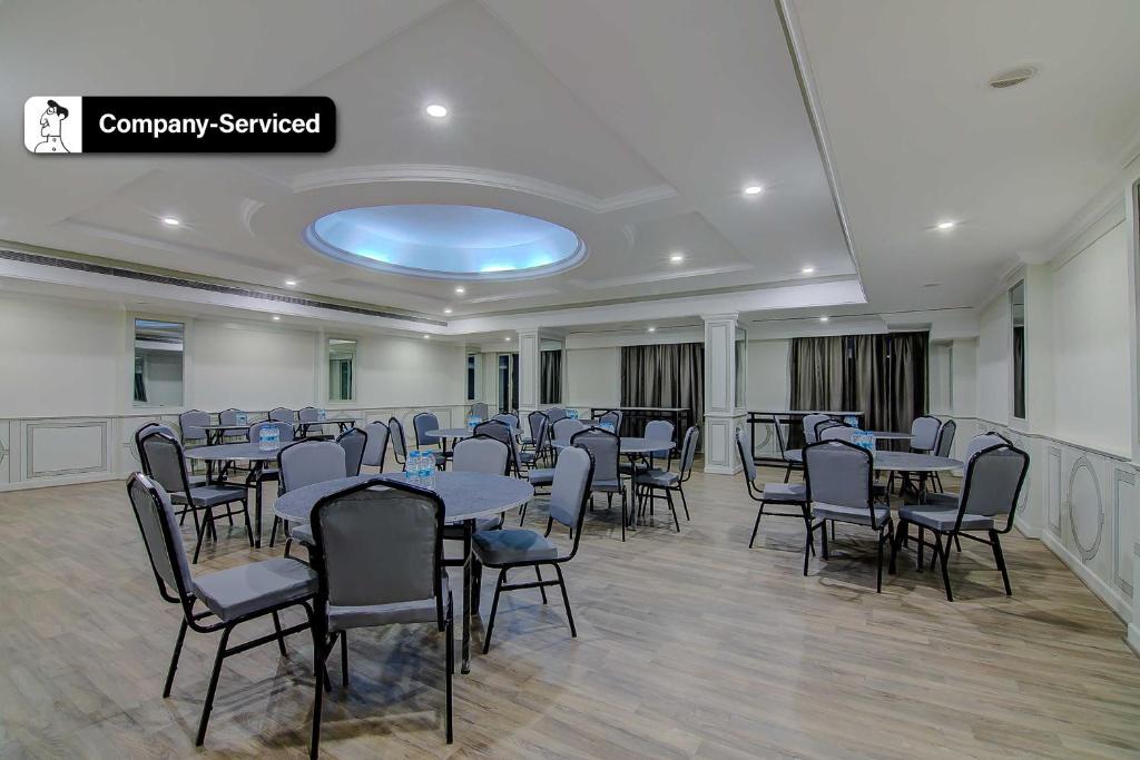 Hotel RS Plaza Qubic Near Delhi Airport في نيودلهي: قاعة احتفالات مع طاولات وكراسي في غرفة