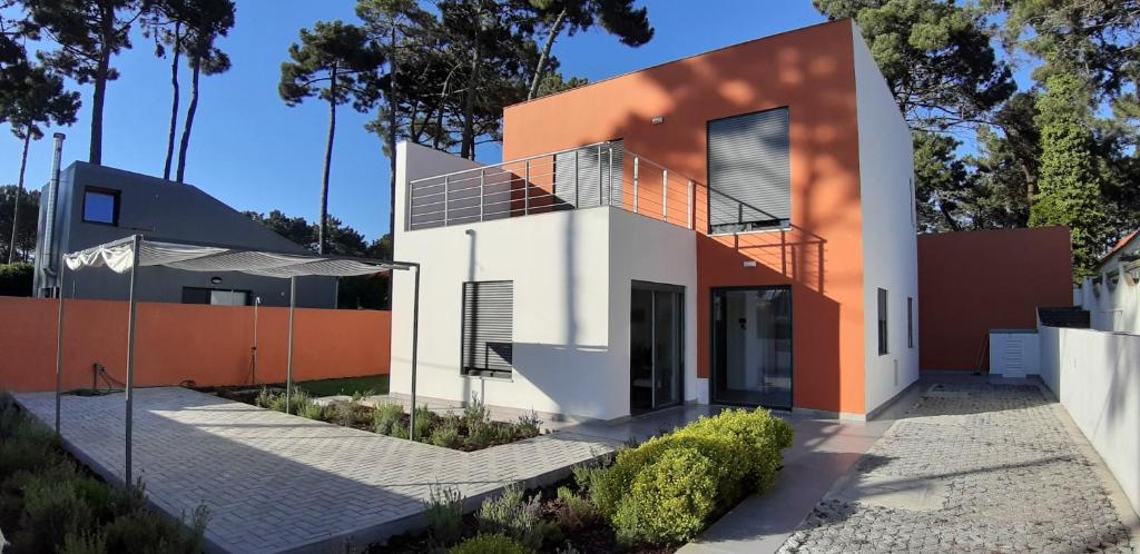 a house with an orange and white facade at Casa da Falésia in Almada