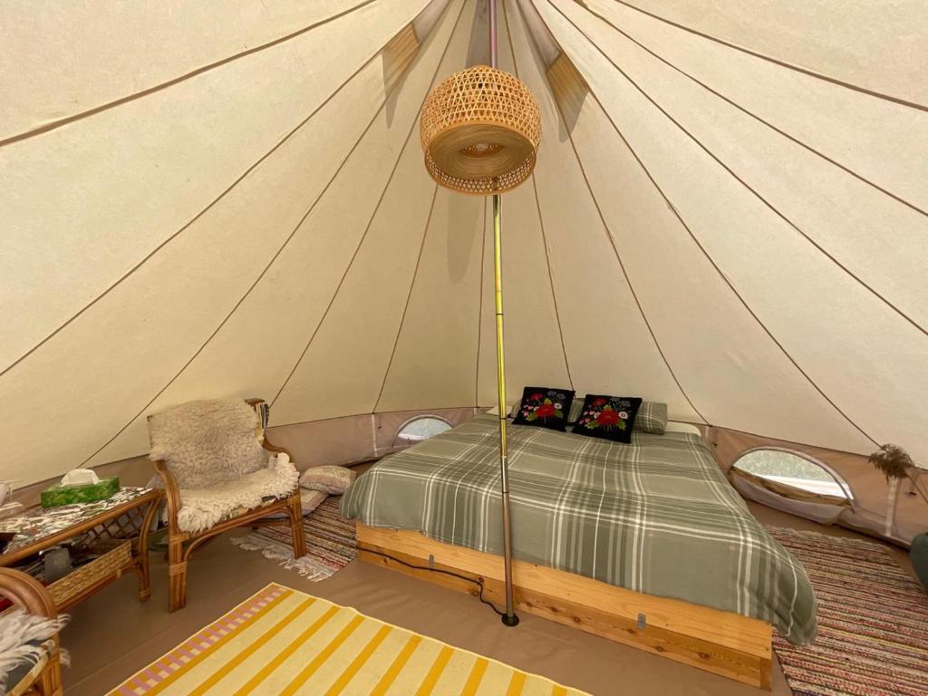 - une chambre avec un lit dans une tente dans l'établissement Pädaste Aerga Sunrise Glamping, à Pädaste