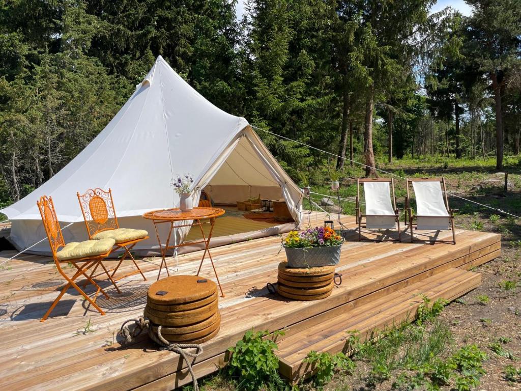 una tenda con sedie e un tavolo su una terrazza in legno di Pädaste Aerga Sunset Glamping a Pädaste