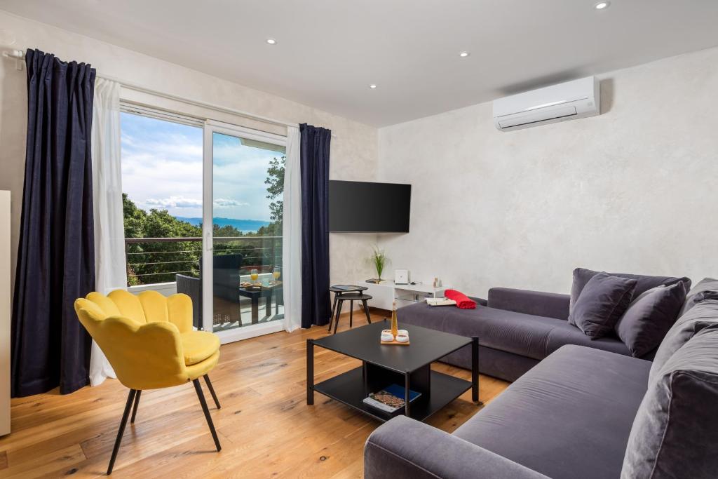 a living room with a blue couch and a yellow chair at Design Apartment Linda in Lovran