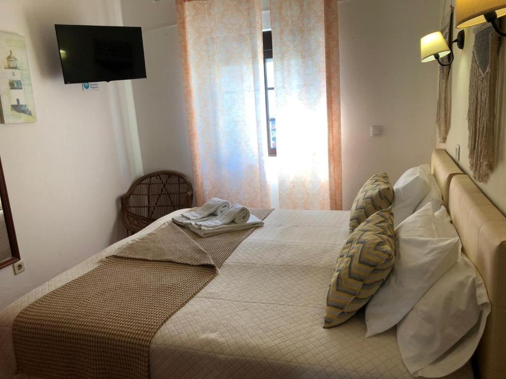 Un dormitorio con una cama con una toalla. en Quartos Abelha, en Porto Covo