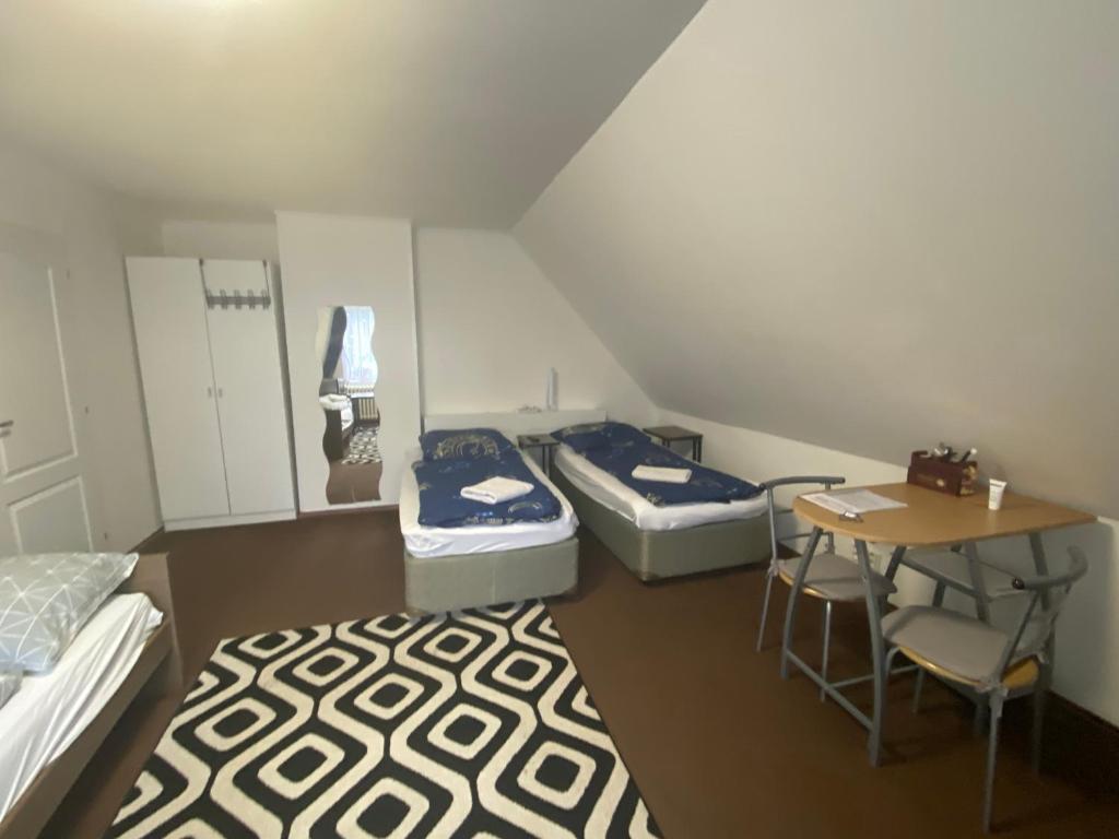 a small room with three beds and a table at Homestay U Hanky in Zdiby