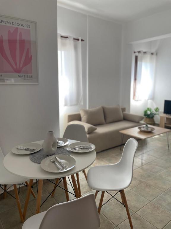 a living room with a table and chairs and a couch at Melivia apartments (2) in Ierissos