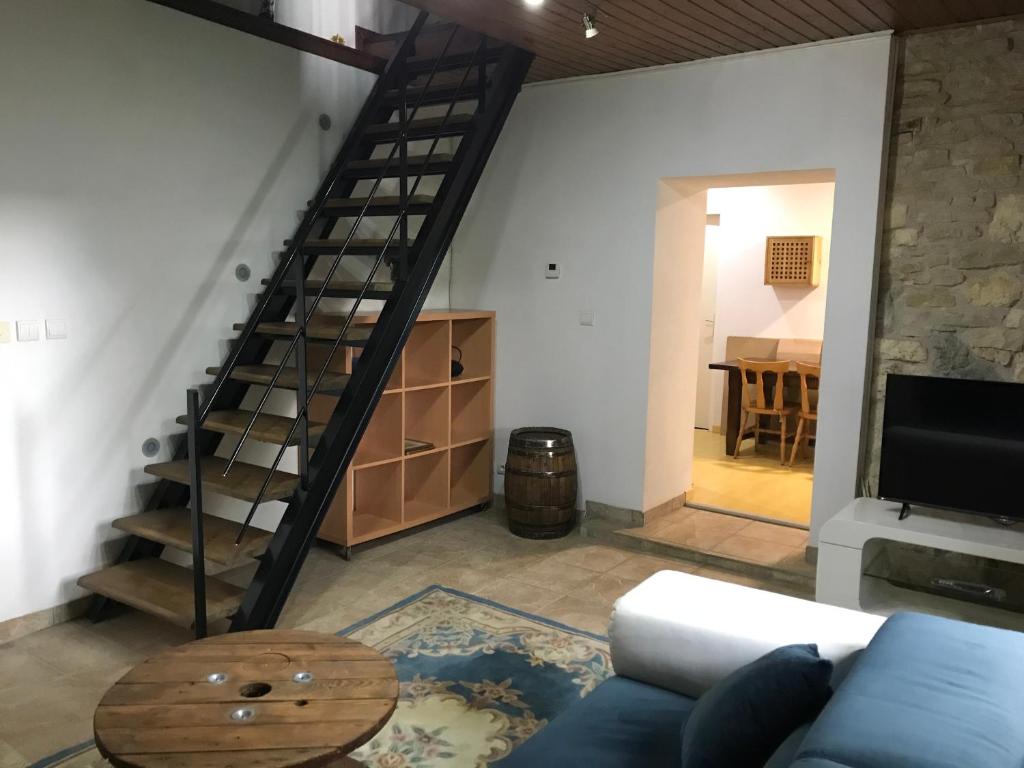 - un salon avec un canapé bleu et un escalier en colimaçon dans l'établissement Logis cosy, à Montbéliard