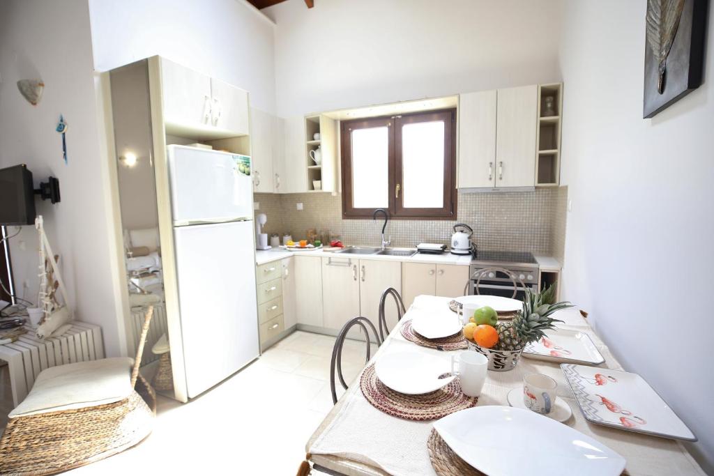 kuchnia ze stołem i białą lodówką w obiekcie Kores Villas w mieście Nydri