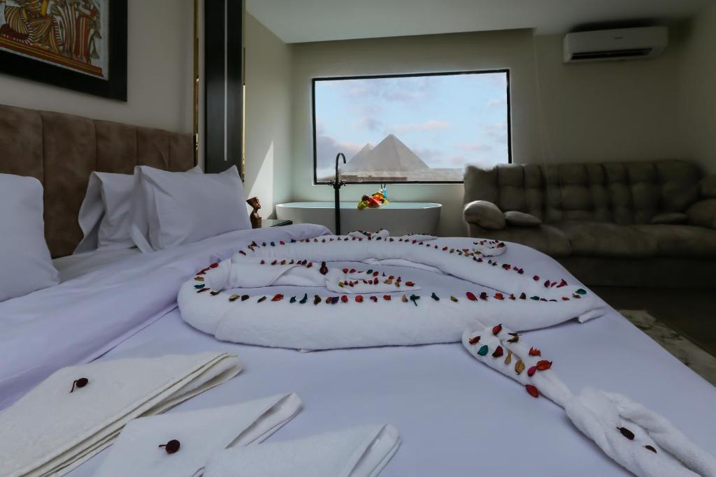a bedroom with a bed with white sheets and utensils at Crowne Pyramids view inn in Cairo