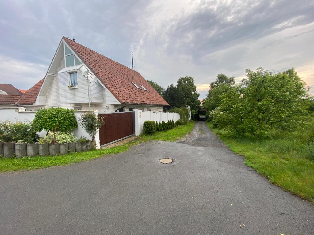 a white house with a red roof and a driveway at Homestay U Hanky in Zdiby