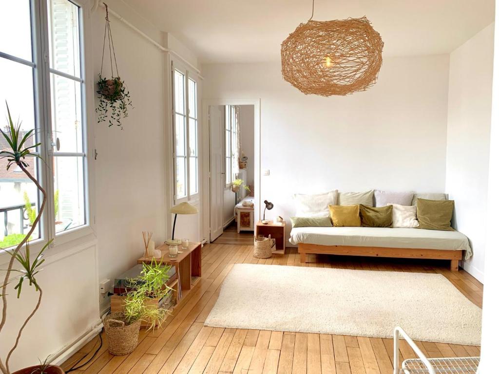 un salon avec un canapé et quelques plantes dans l'établissement Appartement lumineux 3 pièces centre, à Saint-Germain-en-Laye