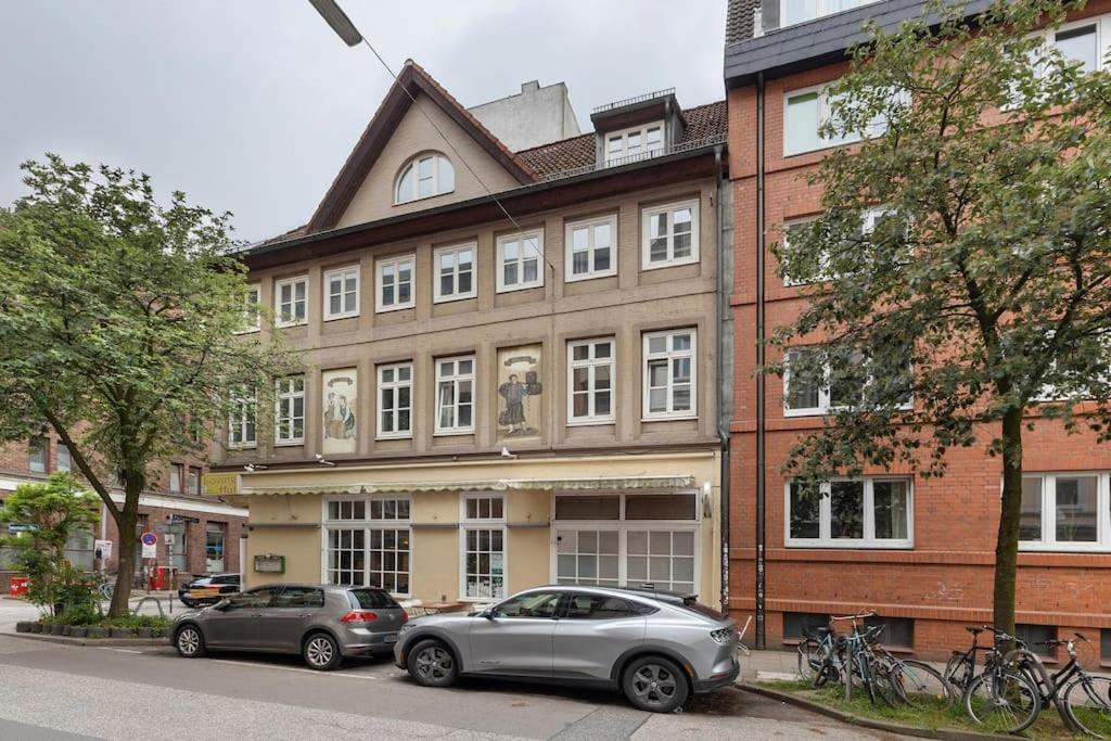 dwa samochody zaparkowane przed dużym budynkiem w obiekcie Wunderschöne 3 Zimmer Wohnung! w mieście Hamburg