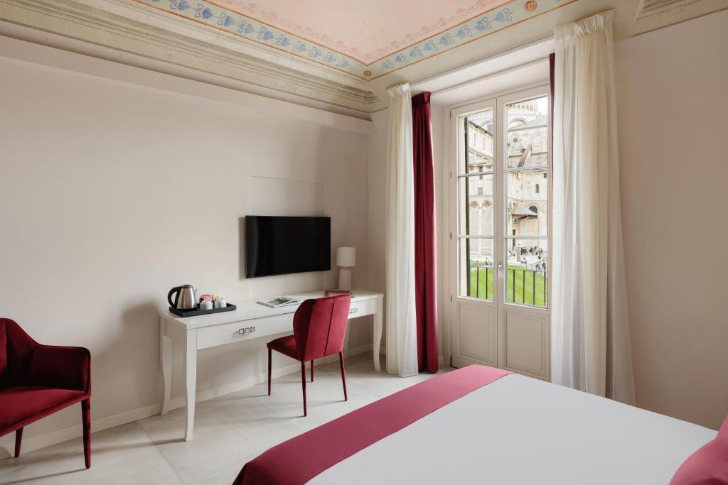 una camera con letto, scrivania e finestra di Prato dei Miracoli Residenza d'Epoca a Pisa
