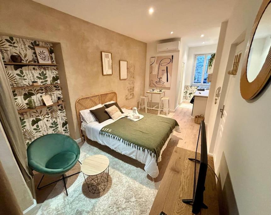 - une chambre avec un lit et une chaise verte dans l'établissement Studio de charme Avignon centre, à Avignon