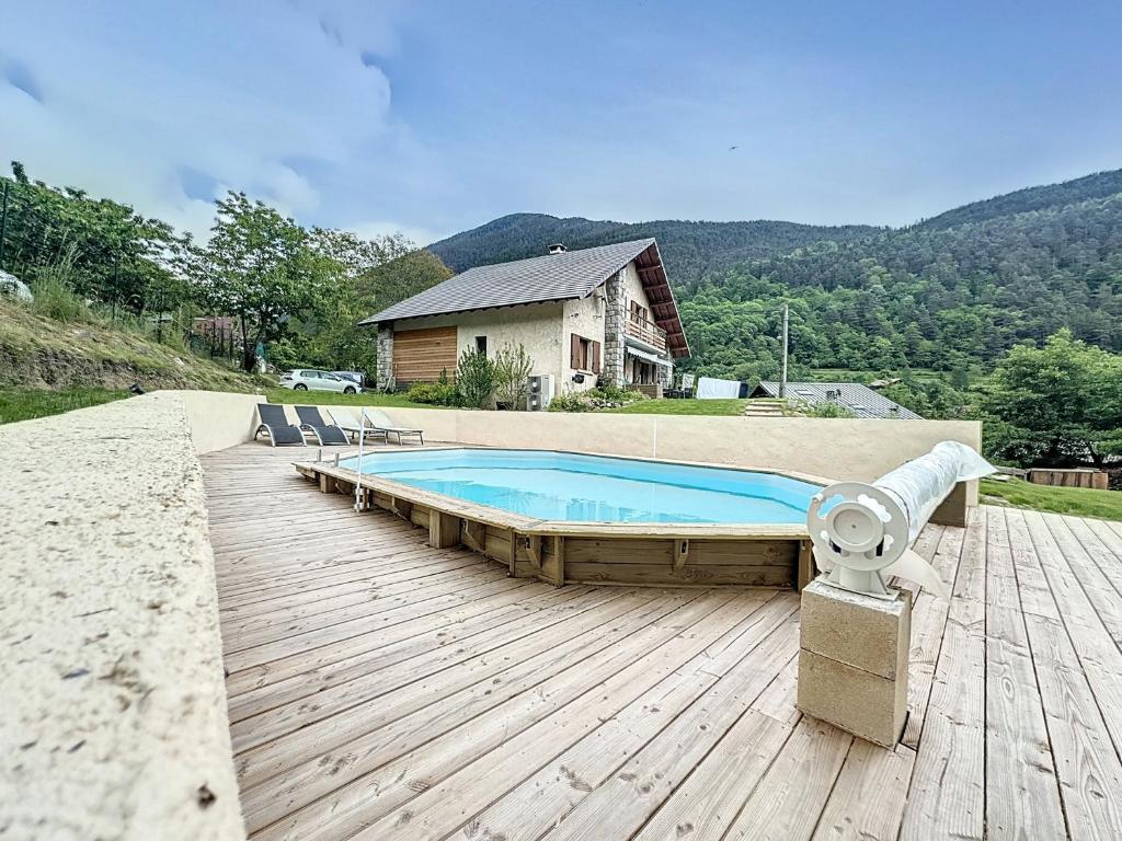 una piscina su una terrazza in legno accanto a una casa di CHALET DON PAPA a Saint-Martin-Vésubie