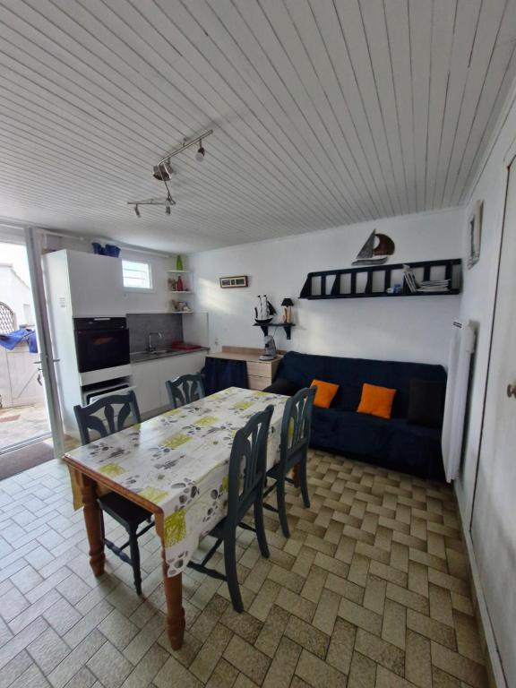 Les Sables VignierにあるAppartement les pieds dans l eauのテーブルと椅子のあるキッチンとリビングルーム