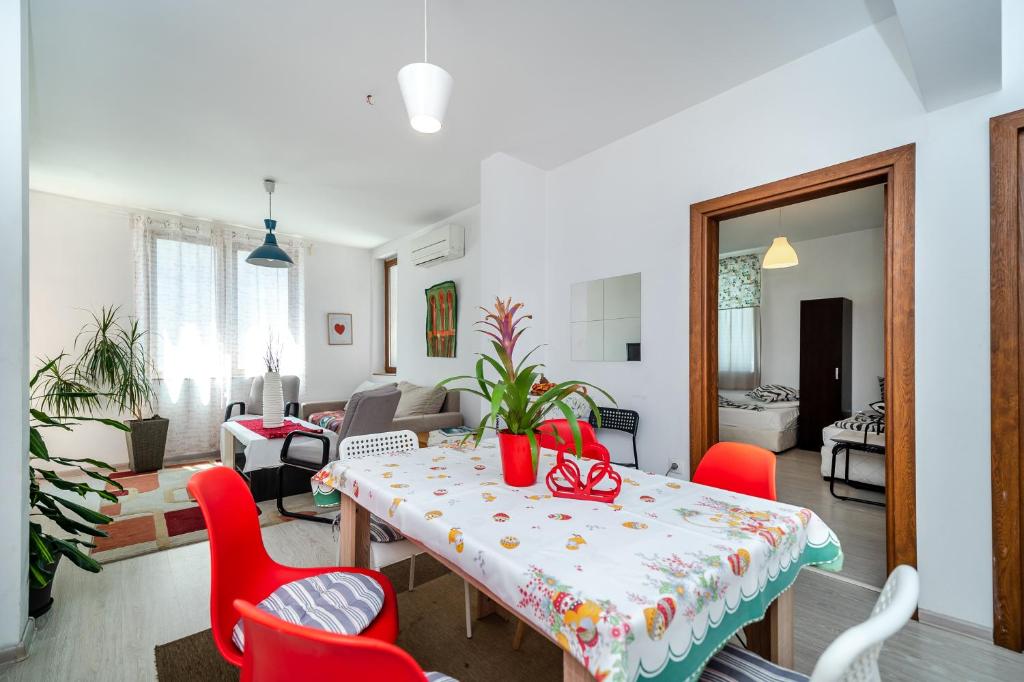 un soggiorno con tavolo e sedie rosse di Bulrock Residance a Sofia
