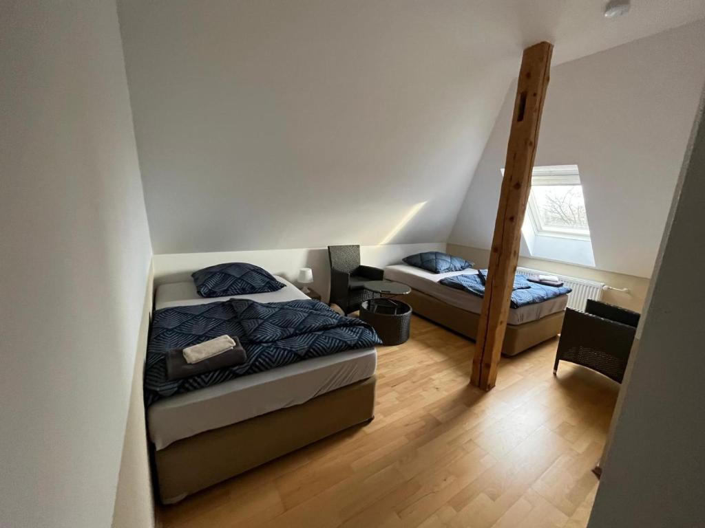 1 dormitorio con 2 camas y escalera en MWM-Pension-Hotel en Meine