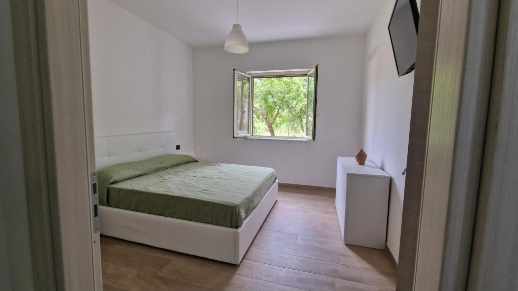 Un dormitorio pequeño con una cama y una ventana. en Appartamenti Palinuro Isca, en Palinuro