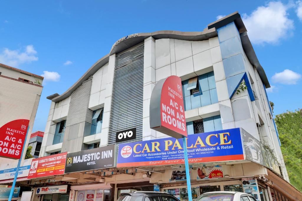 a building with a car palace sign in front of it at OYO Majestic Inn in Trivandrum