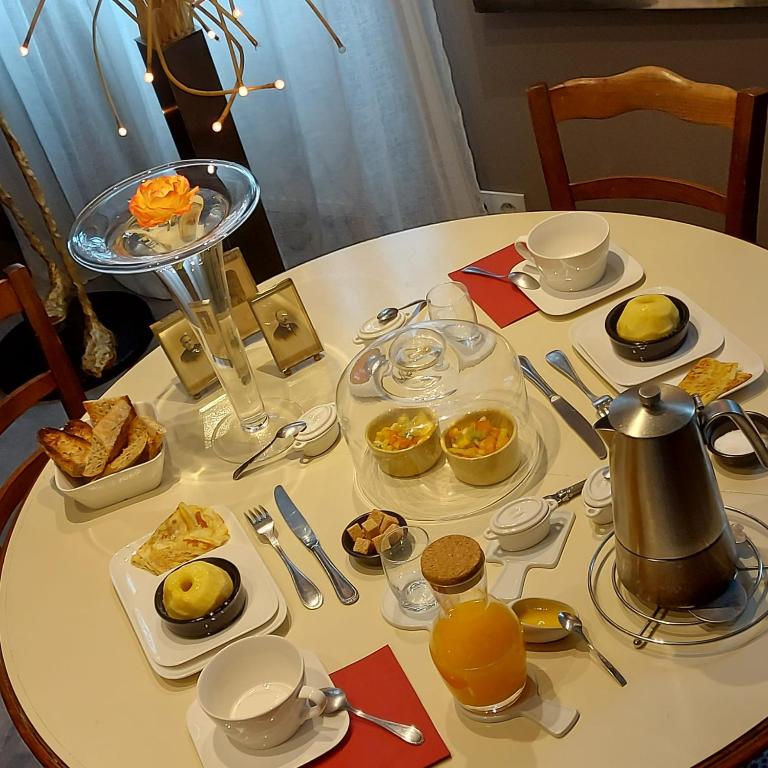 a table with plates of food on top of it at Maison du Lys en Layon in Les Cerqueux-sous-Passavant