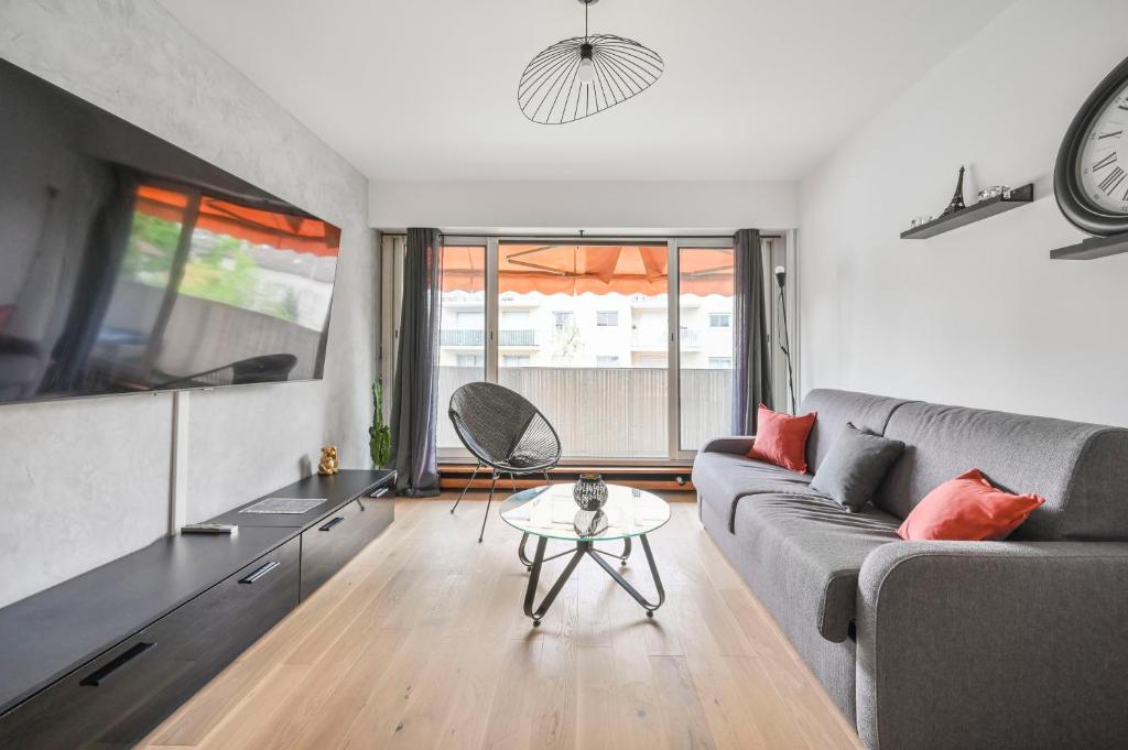 un salon avec un canapé et une table dans l'établissement L’escapade Parisienne - Beau 2 pièces - Proche Paris- Netflix, à Choisy-le-Roi