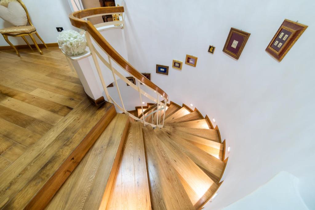 una escalera de caracol en una habitación con suelo de madera en La Villa Del Senatore, en Gravina in Puglia