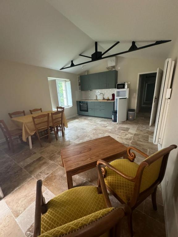 une cuisine et une salle à manger avec une table et des chaises dans l'établissement Maison entre Terre et Mer, à Curzon