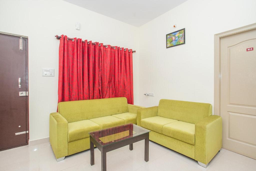 sala de estar con 2 sillas y mesa en Manyata Royal Mac, en Bangalore