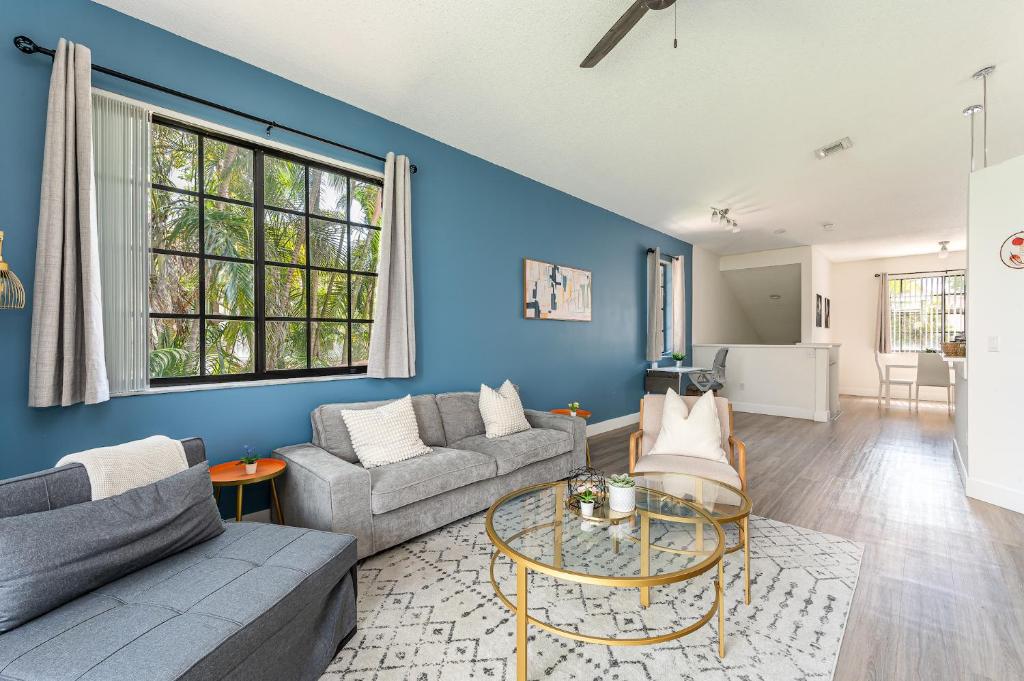 a living room with a couch and a table at Newly Remodeled Lakefront Oasis in Delray Beach