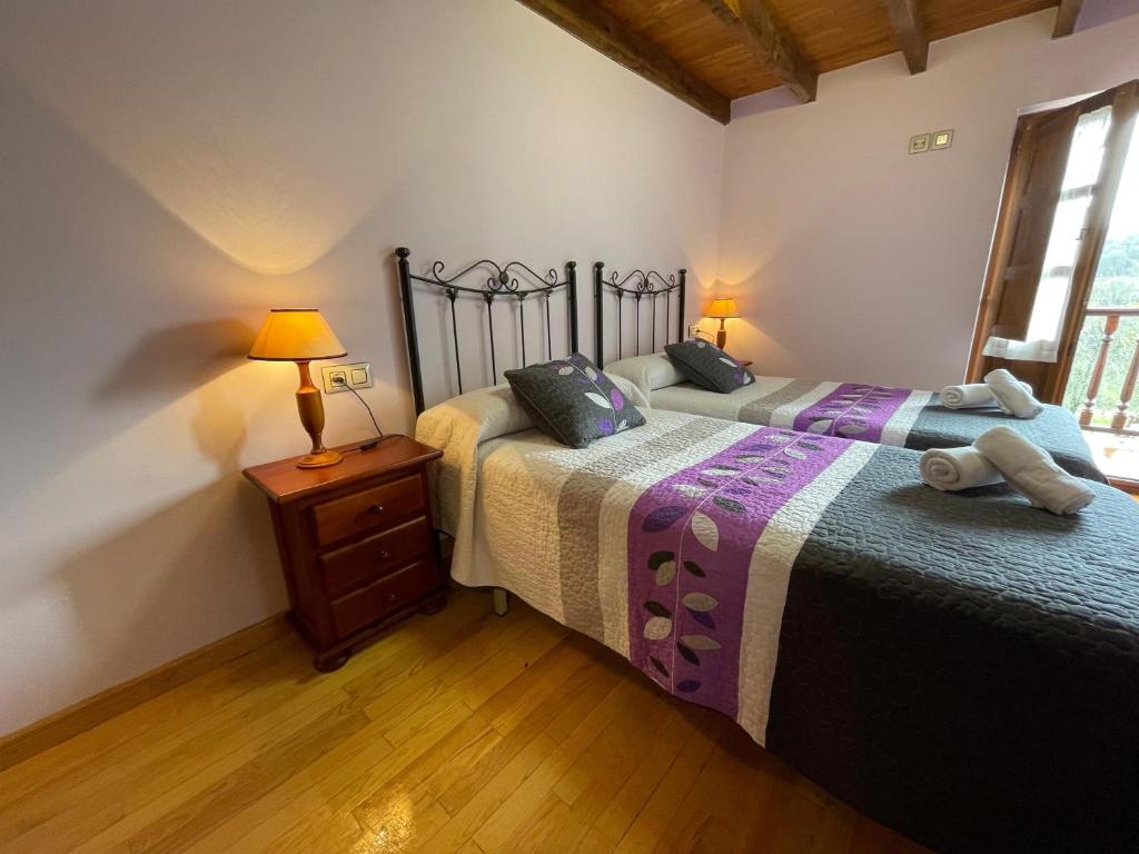 una camera con 2 letti e un comodino con lampada di Casa Iris a Narciandi