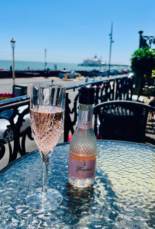 a bottle of wine sitting on a table next to a glass at "The Celebration" Balcony Seafront Apartment in Eastbourne