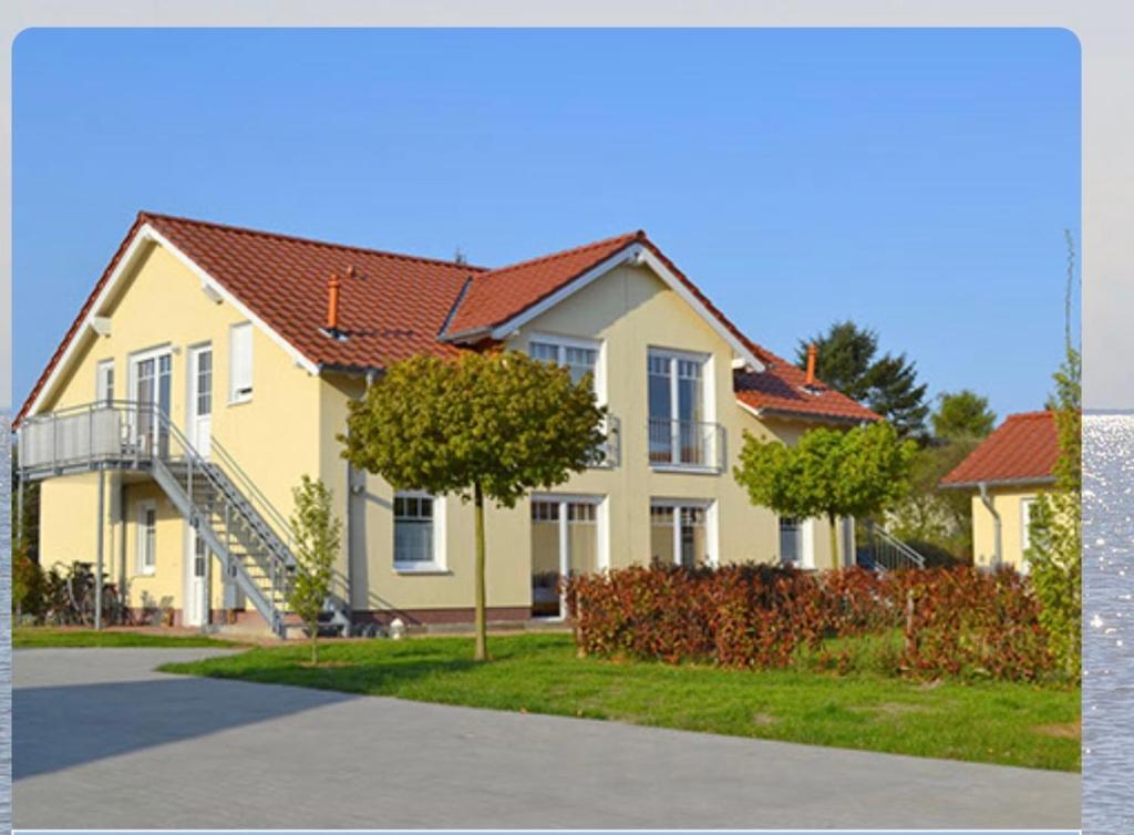une maison jaune avec un escalier devant elle dans l'établissement Am Mühlenkamp daheim 7, 8, 14, à Heringsdorf