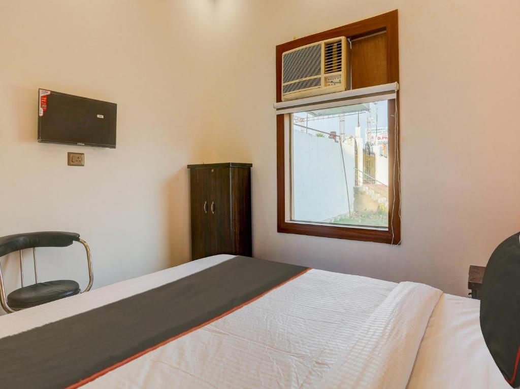 um quarto com uma cama e uma janela com ar condicionado em North Hotel & Lawn em Lucknow