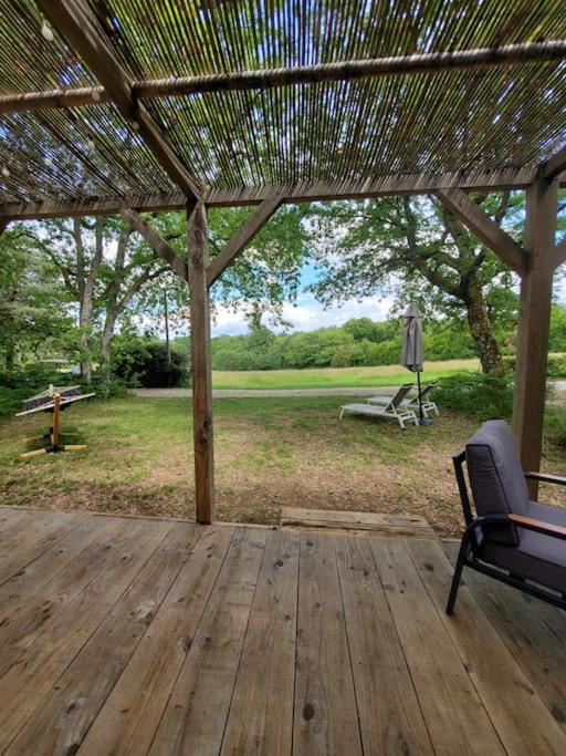 une terrasse en bois avec pergola et banc dans l'établissement Mobile home des bois, à Rouffignac-Saint-Cernin-de-Reilhac