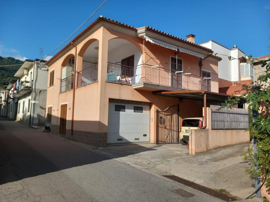 a large house with a garage on a street at Maria s Apartment in Tertenìa