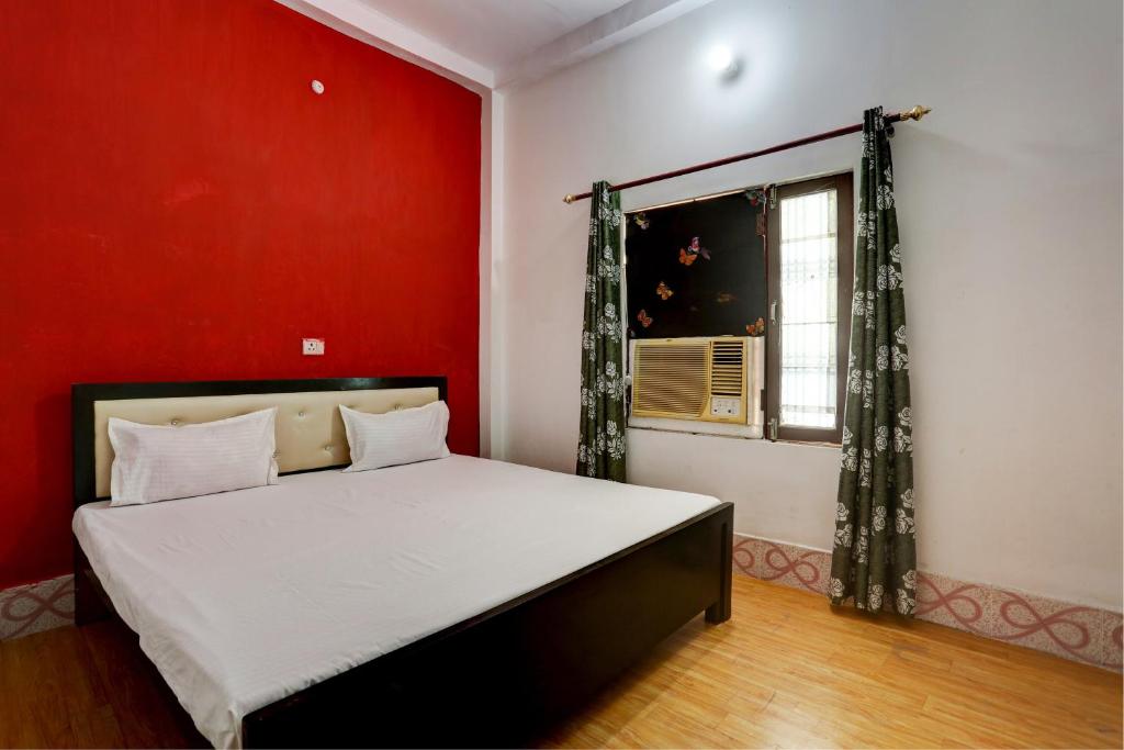 a bedroom with a bed and a red wall at HOTEL SS PARADISE in Lucknow